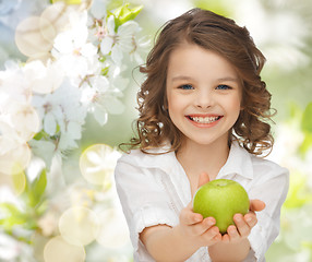 Image showing happy girl holding apple over garden background