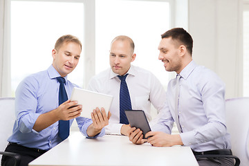 Image showing three smiling businessmen with tablet pc in office