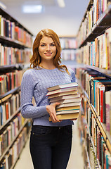 Image showing happy student girl or woman with books in library