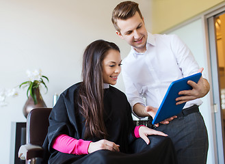 Image showing happy woman and stylist with tablet pc at salon