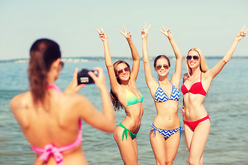 Image showing group of smiling women photographing on beach