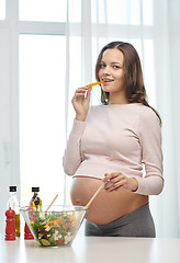 Image showing happy pregnant woman preparing food at home