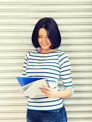 Image showing happy and smiling teenage girl with big notepad