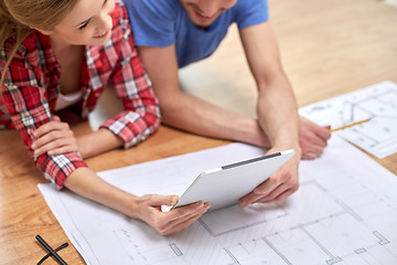 Image showing close up of couple with tablet pc and blueprint