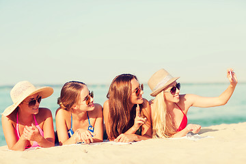 Image showing group of smiling women with smartphone on beach