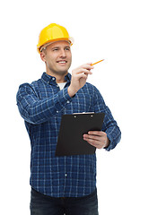 Image showing smiling male builder in helmet with clipboard