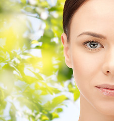 Image showing young woman face over green leaves background