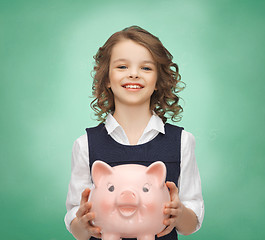 Image showing happy girl holding piggy bank 