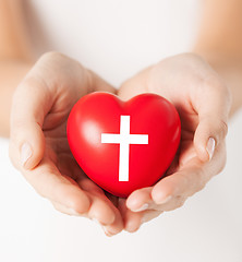 Image showing female hands holding heart with cross symbol