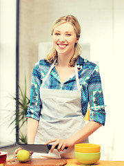 Image showing beautiful woman in the kitchen cutting an apple