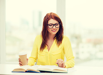 Image showing smiling student girl reading books in library