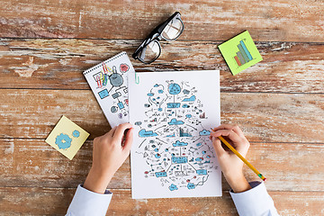 Image showing close up of hands drawing schemes on paper sheets