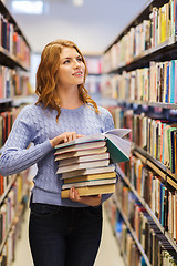 Image showing happy student girl or woman with books in library