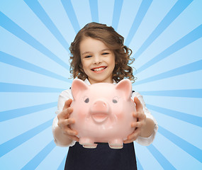 Image showing happy girl holding piggy bank 