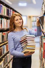 Image showing happy student girl or woman with books in library