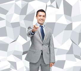 Image showing happy smiling businessman in suit pointing at you