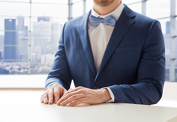 Image showing close up of man in suit and bow-tie at table