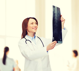 Image showing smiling female doctor looking at x-ray