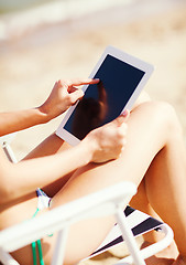 Image showing girl looking at tablet pc on the beach