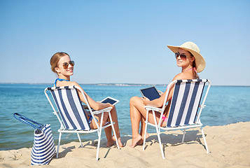 Image showing happy women with tablet pc sunbathing on beach