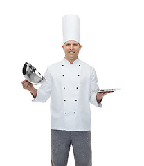 Image showing happy male chef cook opening cloche