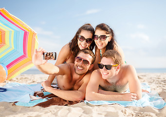 Image showing happy friends taking selfie by smartphone on beach