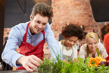 Image showing happy friends cooking and decorating dishes