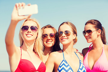 Image showing group of smiling women making selfie on beach