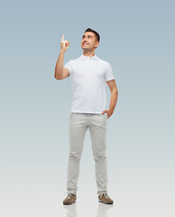 Image showing smiling man pointing finger up