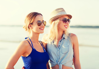 Image showing two smiling women in sunglasses on beach