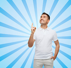 Image showing smiling man pointing finger up