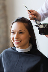 Image showing happy woman with stylist coloring hair at salon