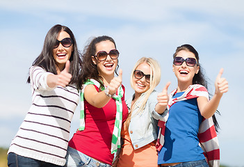 Image showing happy teenage girls showing thumbs up on beach