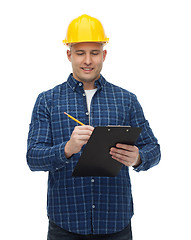 Image showing smiling male builder in helmet with clipboard