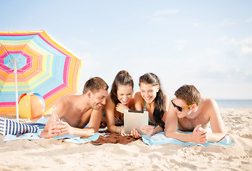 Image showing happy friends with tablet pc on beach