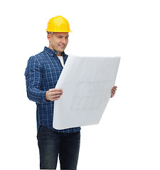 Image showing smiling male builder in helmet with blueprint