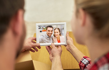 Image showing close up of happy couple looking at family photo