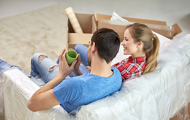 Image showing happy couple relaxing on sofa in new home