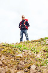 Image showing tourist with beard and backpack raising hands