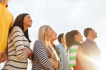 Image showing group of happy friends looking up on beach