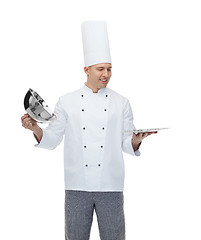 Image showing happy male chef cook opening cloche