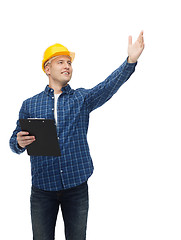 Image showing smiling male builder in helmet with clipboard