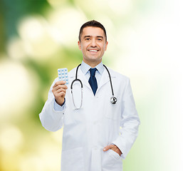Image showing smiling male doctor in white coat with tablets