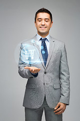 Image showing businessman showing shopping trolley hologram