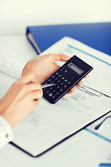 Image showing woman hand with calculator and papers