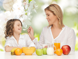 Image showing happy mother and daughter eating breakfast