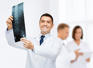 Image showing smiling male doctor holding x-ray at hospital