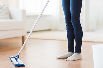 Image showing close up of woman with mop cleaning floor at home