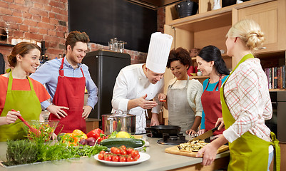 Image showing happy friends and chef cook cooking in kitchen