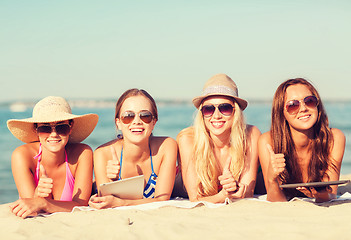 Image showing group of smiling young women with tablets on beach